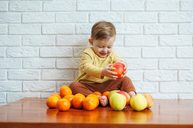 1つの新鮮なジューシーな赤いリンゴを食べるかわいい笑顔の子供幼児のための健康的な果物