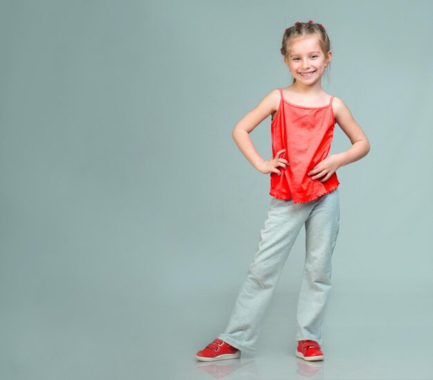 Cute smiling little girl gymnast in studio