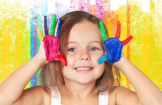 Foto bambina sorridente sveglia con le mani in vernice isolate