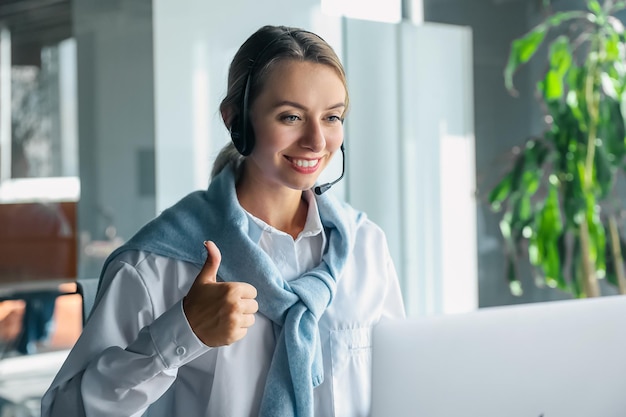 Cute smiling woman having a video call and looking contented