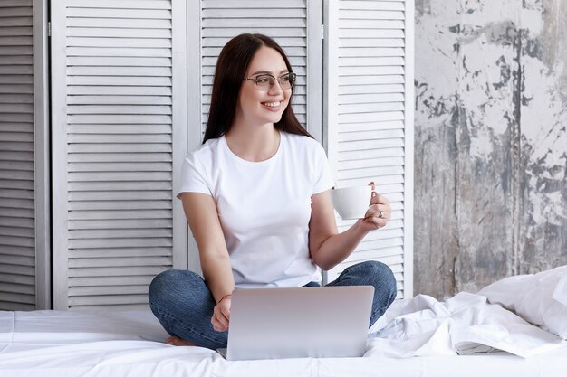 Cute smiling woman using digital tablet at home