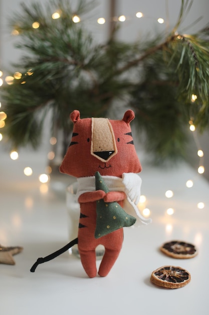 Cute soft toy tiger with decorations on a cozy christmas or new year background symbol of  oriental ...