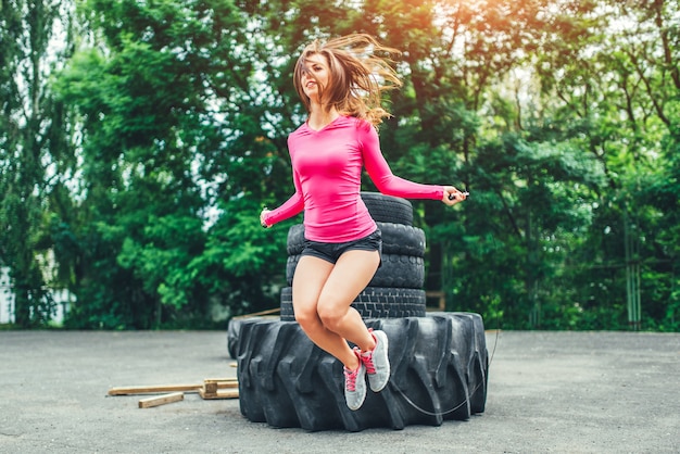 Cute sporty girl with rope training outdoor