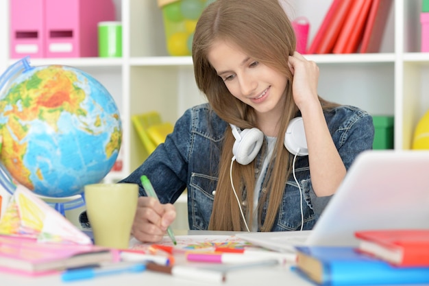 Cute  student girl at class with laptop and tea