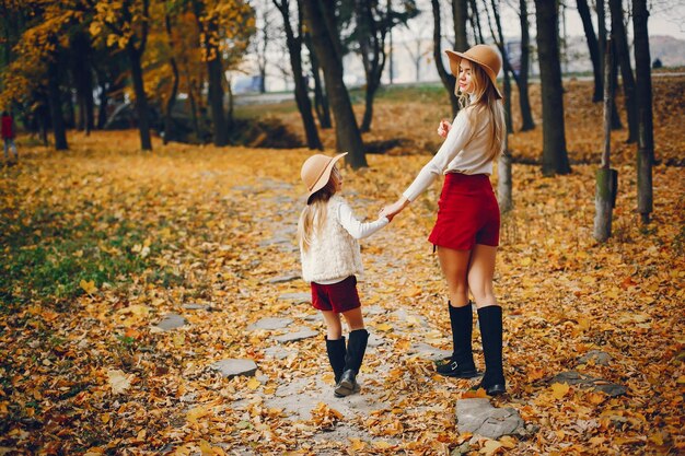 Foto famiglia carina e elegante in un parco autunnale