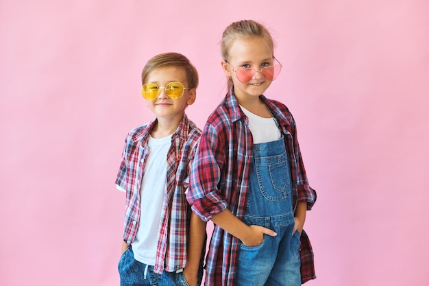 Cute stylish kids in color sunglasses looking at camera a