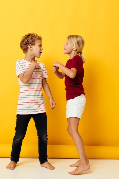 Cute stylish kids cuddling fashion childhood entertainment on colored background