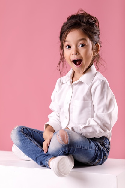 Cute surprised little girl in white shirt with hairstyle