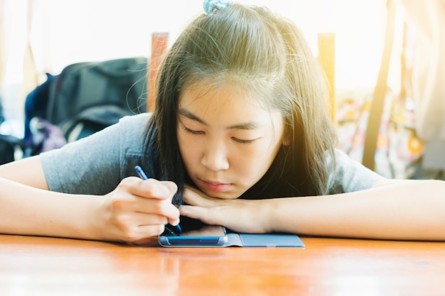 Cute Sweet Asian girl enjoy drawing on smart phone 