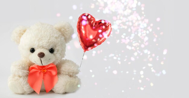 Cute teddy bear holds a heart ball Valentine with a bear