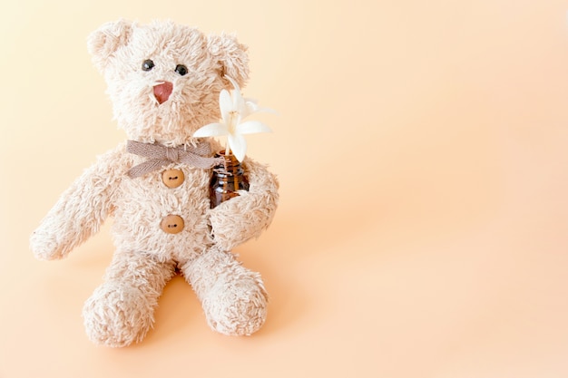 Cute teddy bear with flowers on pastel background. Happy animal relaxing and enjoying  