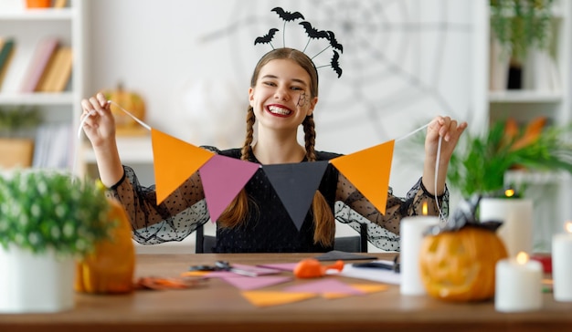 Cute teen with carving pumpkin Happy girl preparing for Halloween Funny kid at home