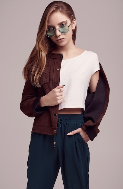 Cute teenage girl in fashion jacket and color glasses