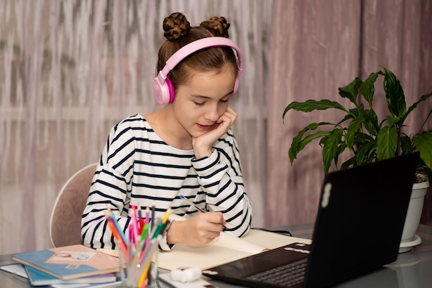 A cute teenage girl studying from home school technology
education