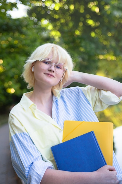 写真 フォルダーと手にノートを持つかわいい 10 代の少女縦の肖像画