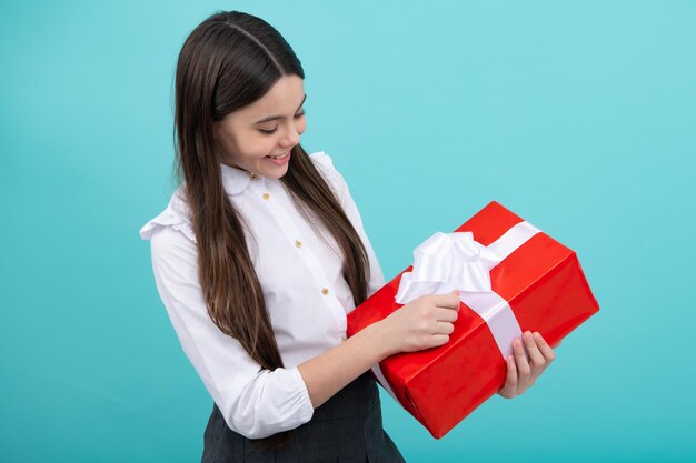 Cute teenager child girl congratulate with valentines day\
giving romantic gift box present greeting and gifting concept\
surprised emotions of young teenager girl