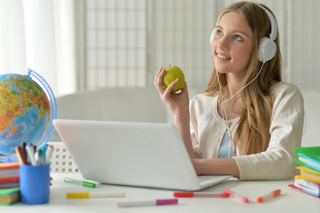 Photo cute teenager girl using computer with apple