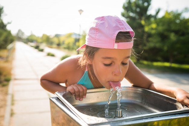 かわいいのどが渇いて女の子がシンクから水を飲む