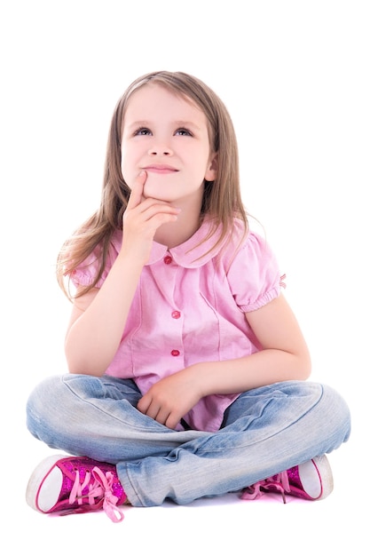 Cute thoughtful little girl sitting isolated on white background