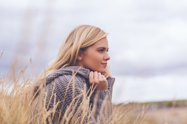 Cute thoughtful young woman lying at beach