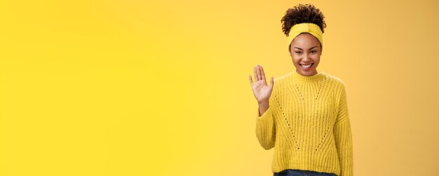 Foto la giovane ragazza carina, timida e amichevole, vuole trovare nuovi amici, sembra piacevole, sorridendo in modo affascinante e felicemente agitando