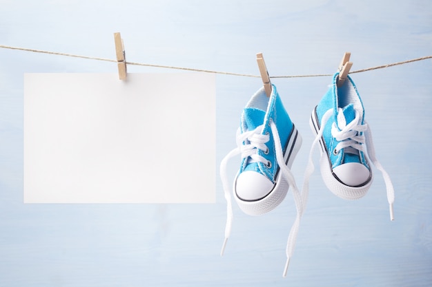 Cute tiny baby shoes on a wooden background with space for text