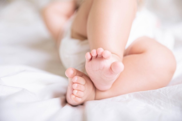 Photo cute tiny legs of baby girl on the bed