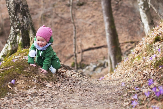 Photo cute toddler baby on spring forest full of wild irises spring blossom in the forest harmony hope