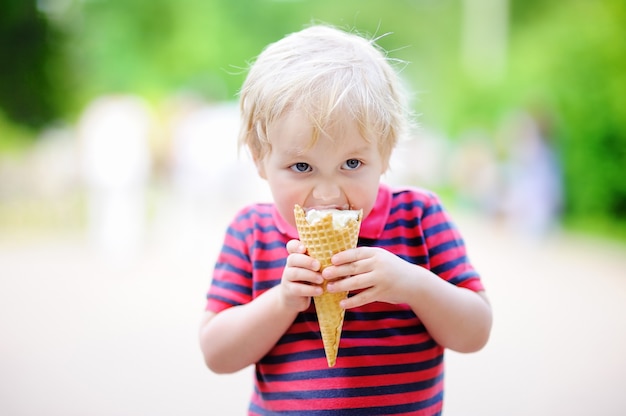 バニラアイスクリームを食べるかわいい幼児男の子