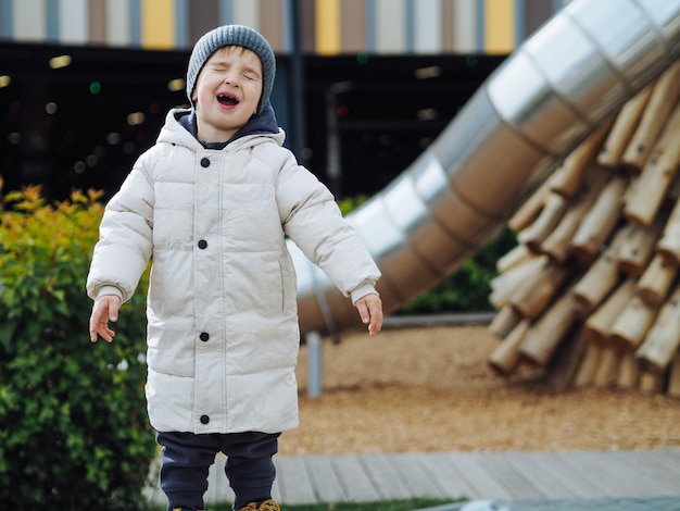 Photo cute toddler boy in fashionable casual warm clothes laughting in wooden eco style playground