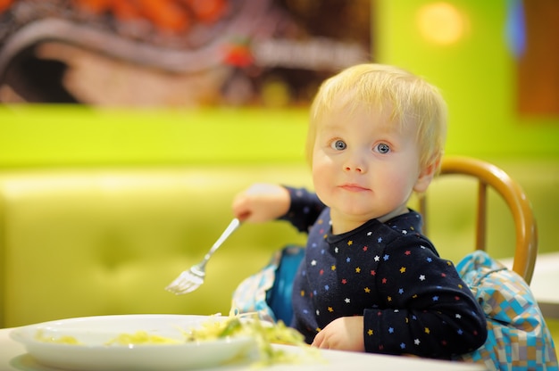 Cute toddler boy at the indoors cafe