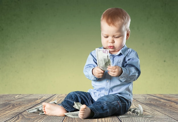 Cute toddler boy playing with money