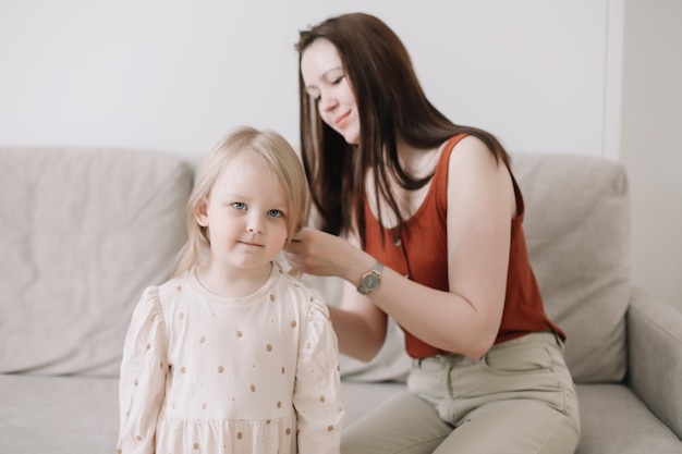 La figlia sveglia del bambino e la madre felice nell'accogliente stanza luminosa a casa amano il concetto di famiglia di festa della mamma