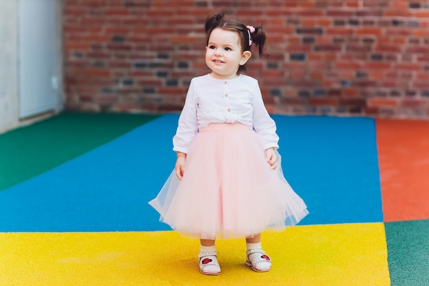 Cute toddler girl in ballerina costume at beautiful summer garden