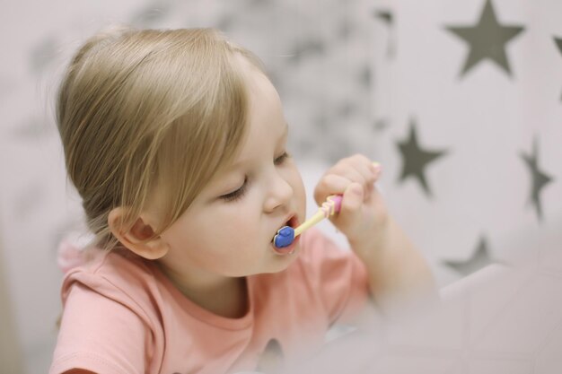 Cute toddler girl brushing teeth in the bathroom Teeth cleaning dental care