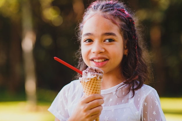 Ragazza sveglia del bambino che mangia il gelato