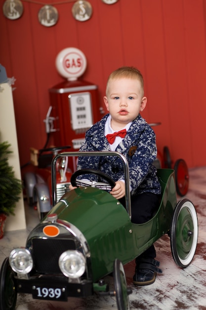 かわいい幼児はおもちゃの車で遊んで、おもちゃのタイプライターの飛行機に乗って、幸せな子供時代