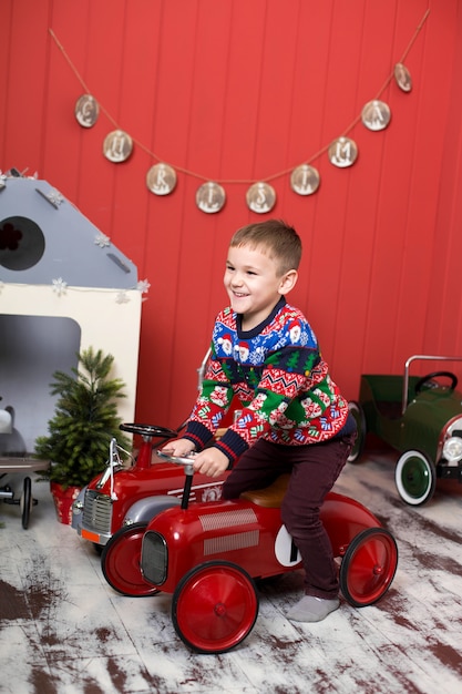 Cute toddler is playing with toy red cars