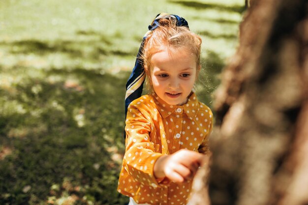 屋外で自然を探索するかわいい幼児の子供夏の森で遊ぶ愛らしい少女公園で晴れた日に植物と生態学のテーマを発見する好奇心旺盛な子供幸せな子供時代