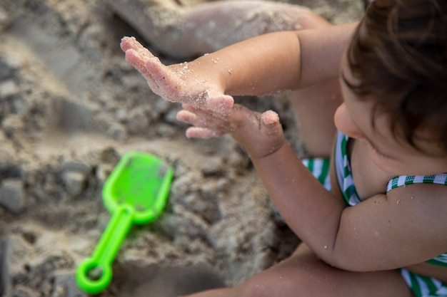 cute toddler kid playing in the sand on the beach. top view.