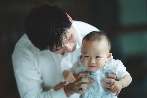 Cute toddler little child family concept baby learning to walk with father and mother to help care and holding hand first step with childhood parent support small love portrait little boy at home