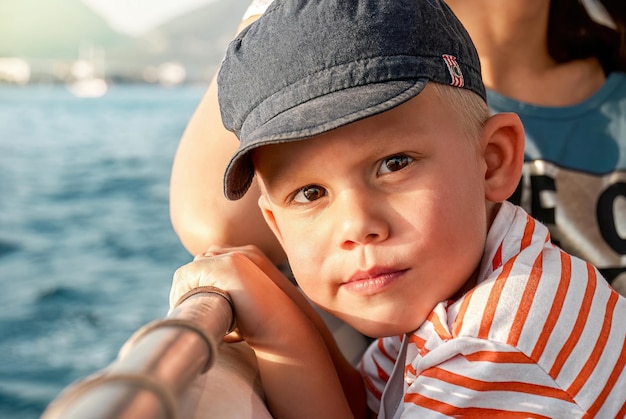 Cute toddler with mother enjoys boat trip sailing in sea past coast of Marmaris