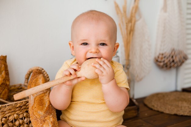 Cute toddler in the wooden kitchen of the house