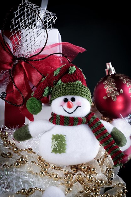 Cute toy box snowman with gifts on a black background