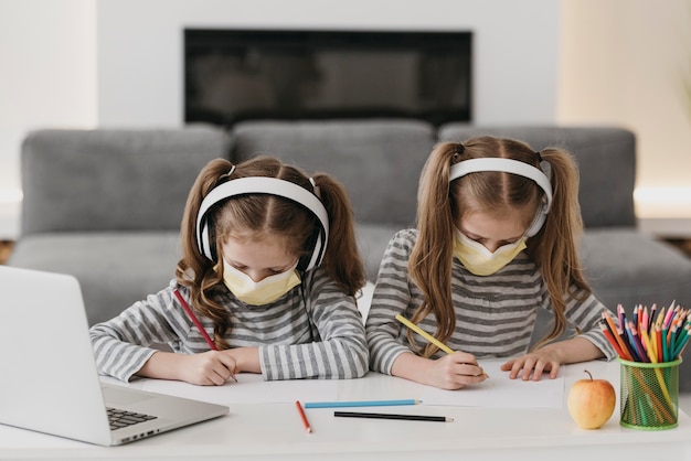 Photo cute twins wearing medical masks inside