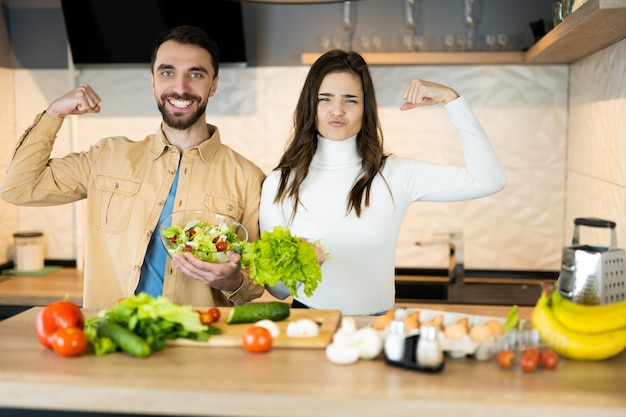 Cute vegetarian couple is showing how healthy and strong they are.