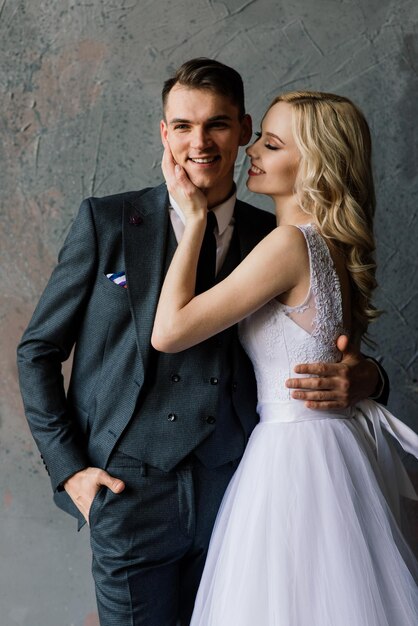 Cute wedding couple in the interior of a classic studio decorated They kiss and hug each other