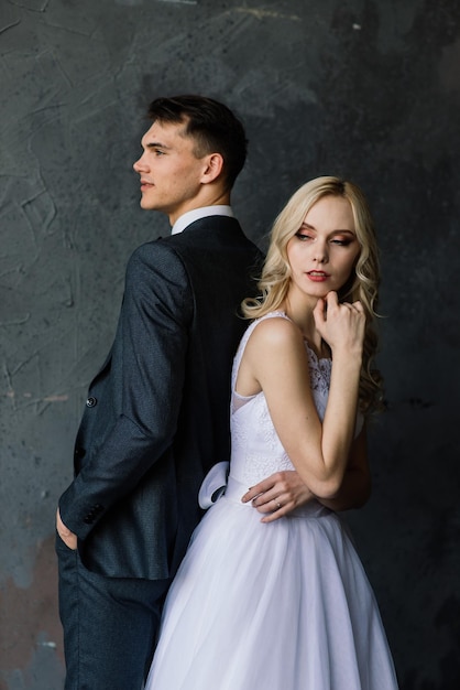 Cute wedding couple in the interior of a classic studio decorated They kiss and hug each other