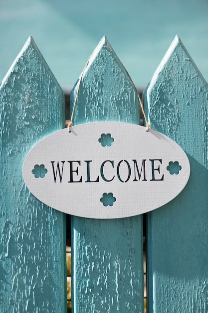 Photo cute welcome sign on blue fence