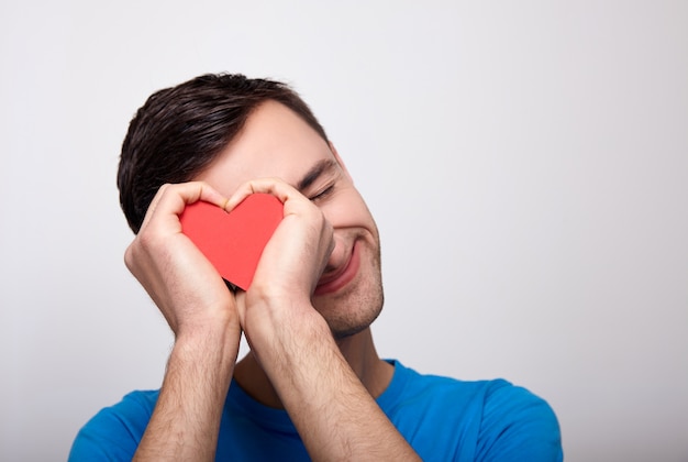 a cute white young man with a red heart in his hands.
